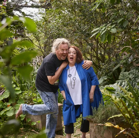 Wendy and her husband Brendan laughing together in their leafy garden.