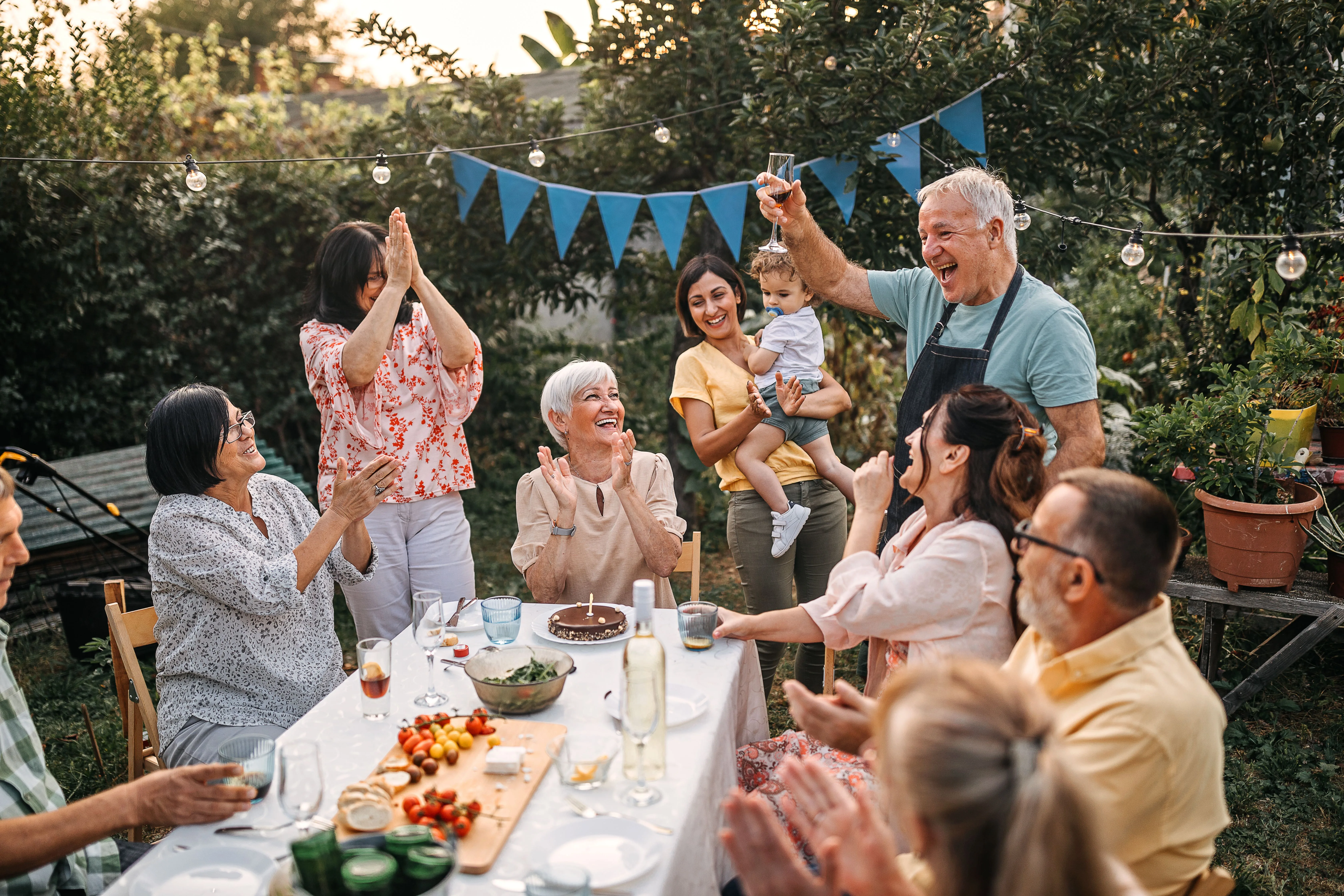 Group of senior men and women enjoying at a party at backyard