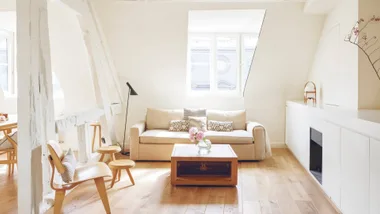 A light living room with couch, coffee table, lamp and chairs