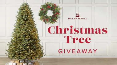 Balsam Hill giveaway banner with a decorated Christmas tree and wreath in a white-paneled room.