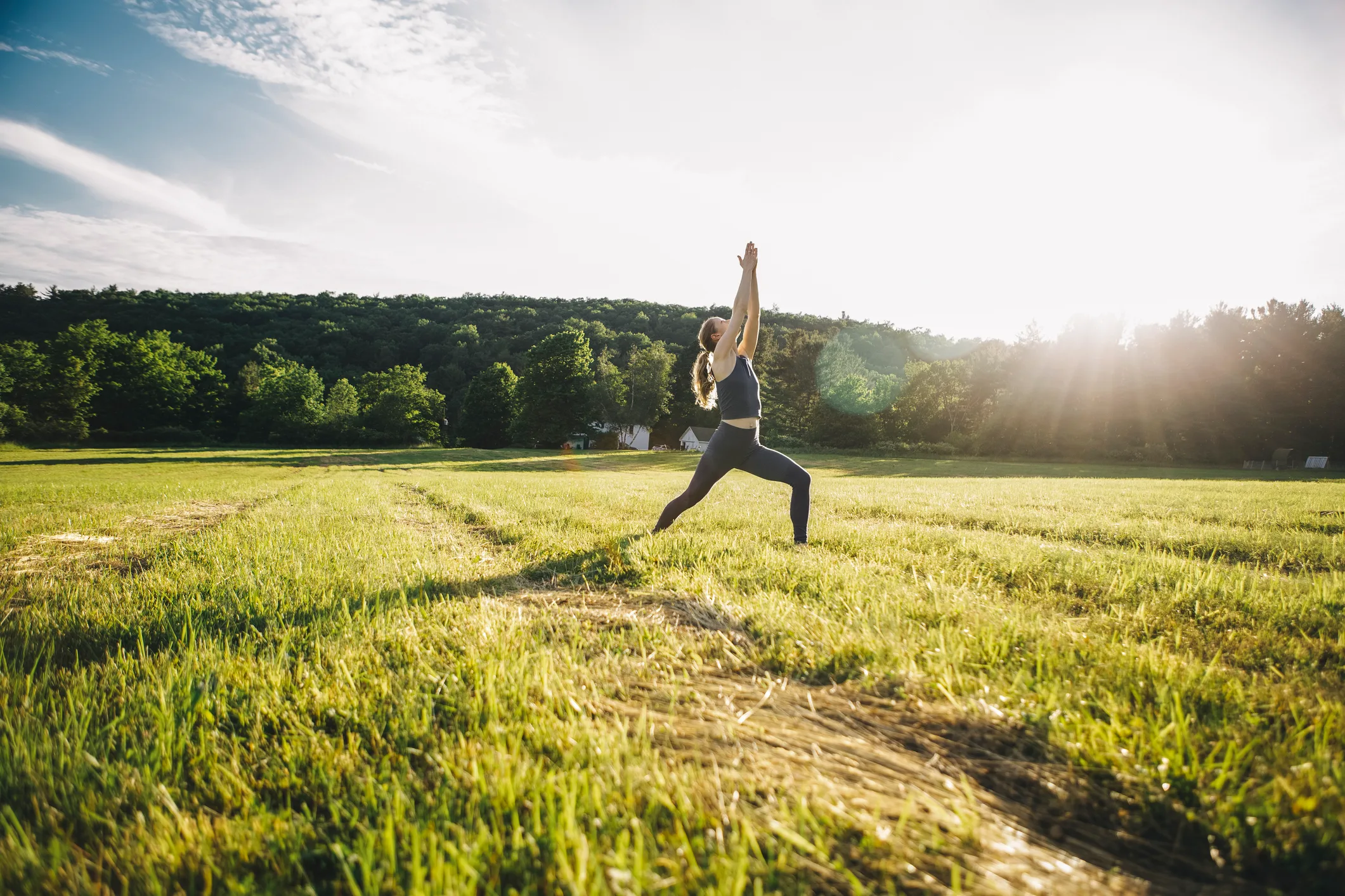 Woman practising yoga in nature to represent coping with stress caused by feeling overwhelmed.