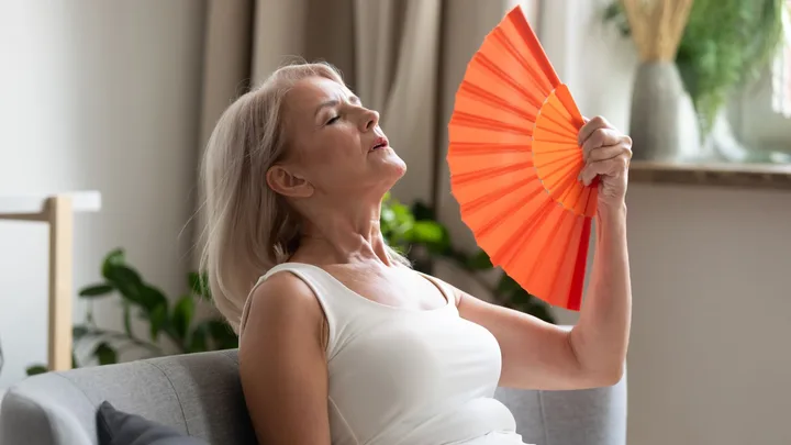 Mature woman fanning herself to cool down
