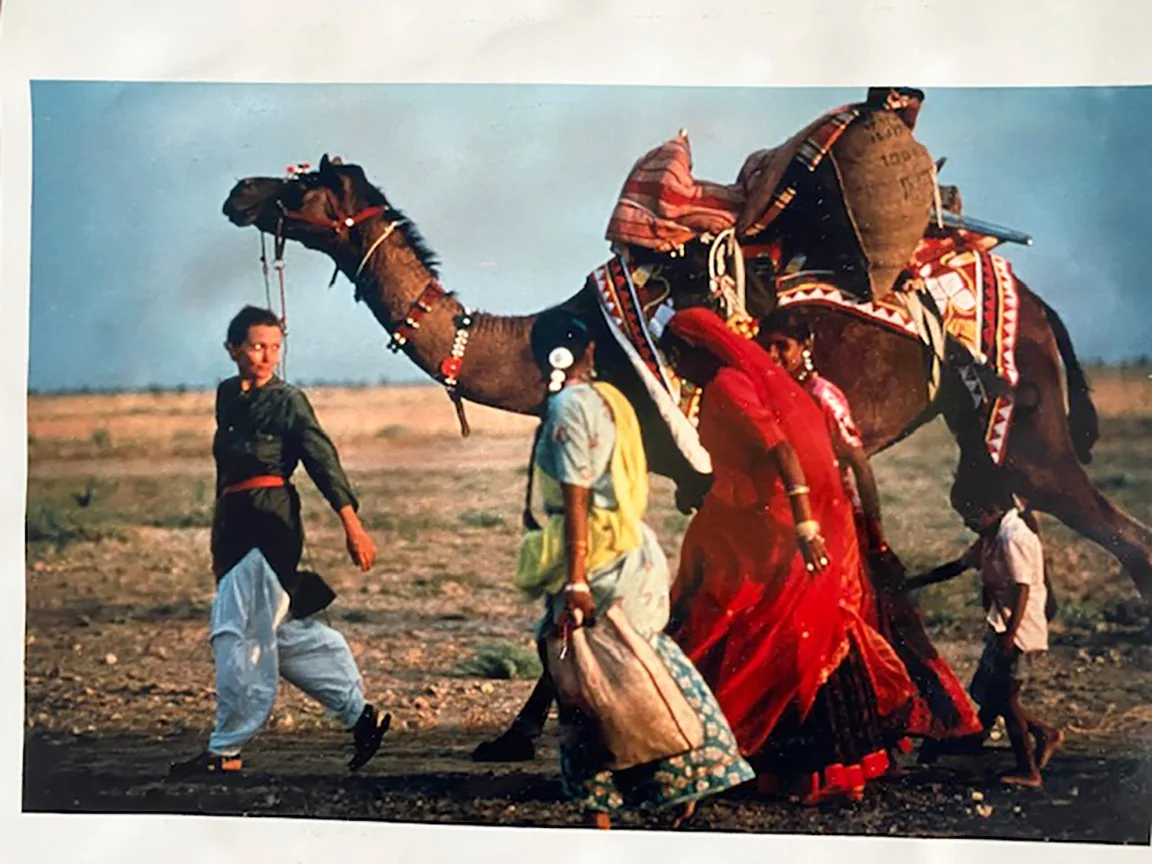 Robyn Davidson with a camel and two people in the desert