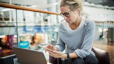 Woman in airport looking at travel money options