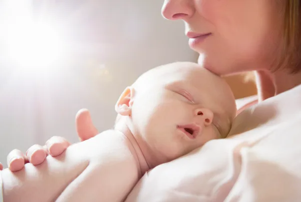 baby sleeping on mother's chest