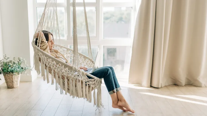 Woman in a hammock looking at computer