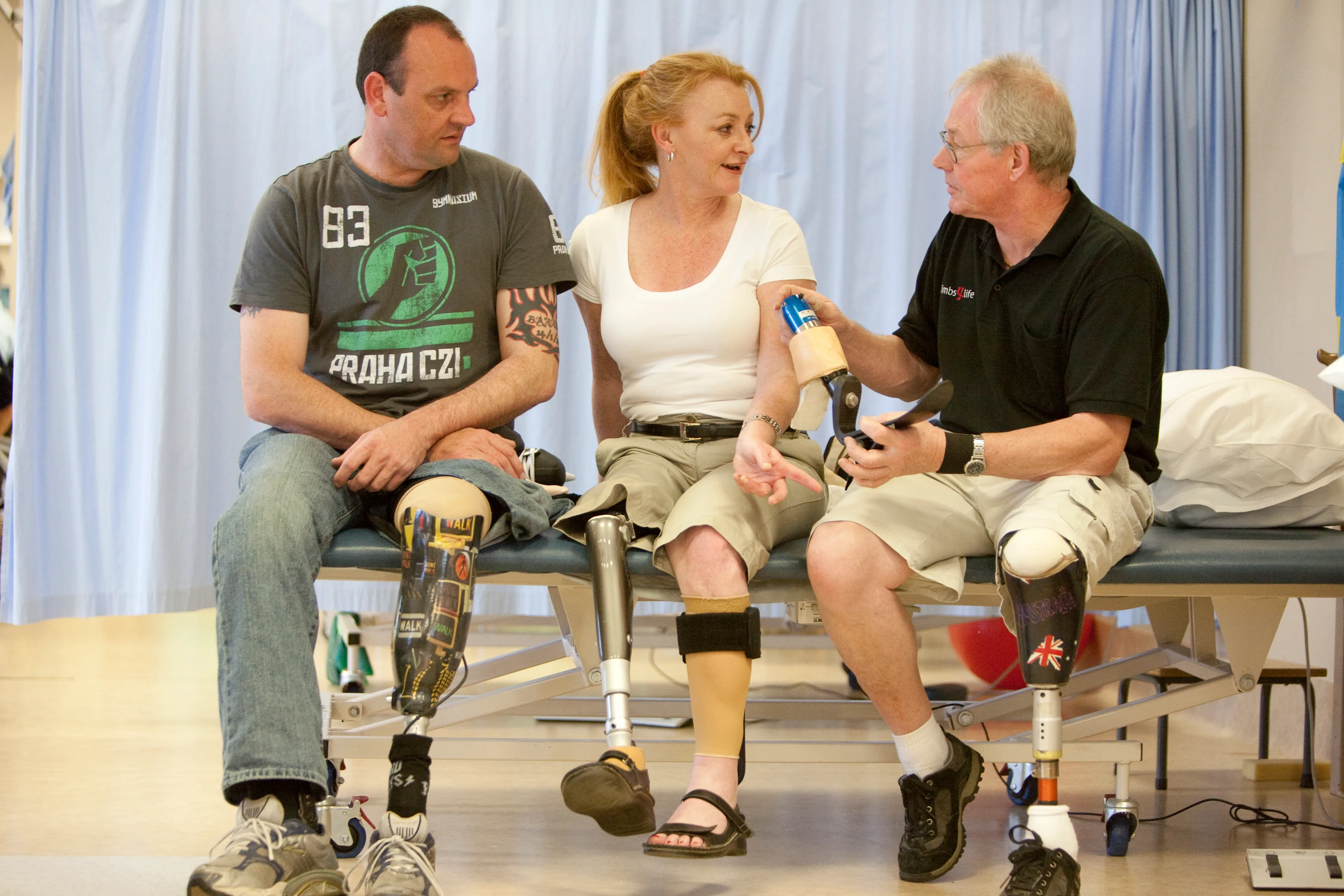 Melissa Noonan wearing shorts and a T-shirst sits with two other amputees in a peer support group.