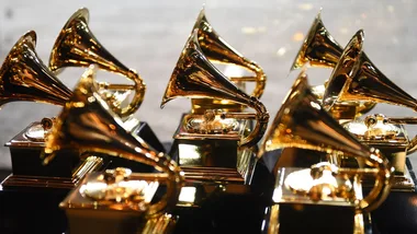 Golden Grammy Award trophies displayed in multiple rows.