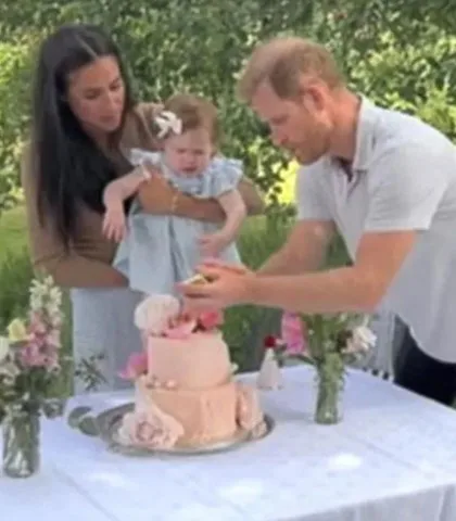 the duke and duchess of sussex and princess lilibet cutting the cake at her 1st birthday party