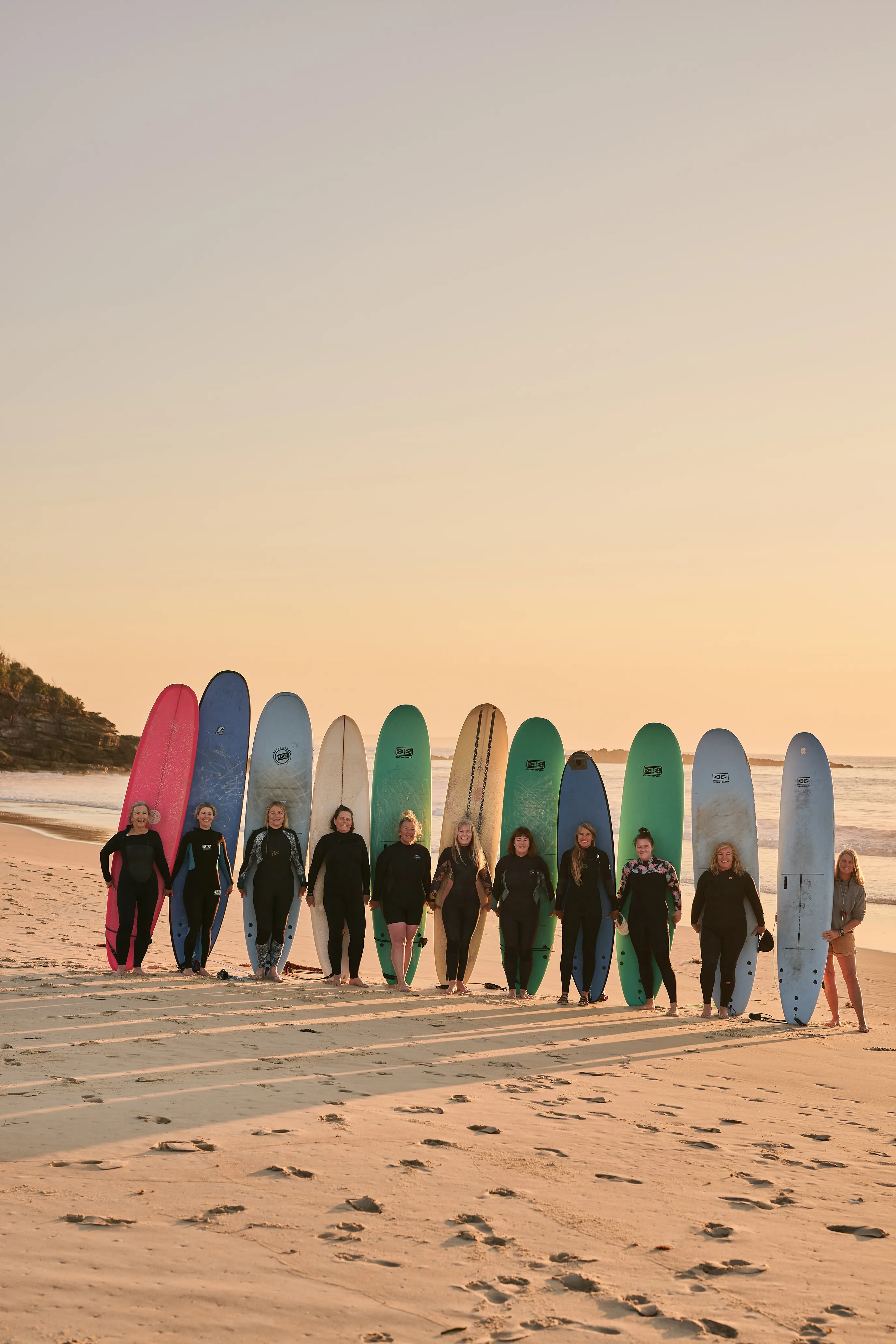 Australian female surfers on the beach with their surfboards.