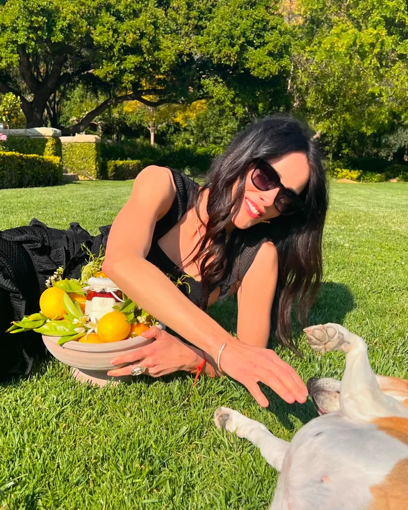 Abigail Spencer with American Riviera Orchard jam petting one of her dogs Mamma Mia