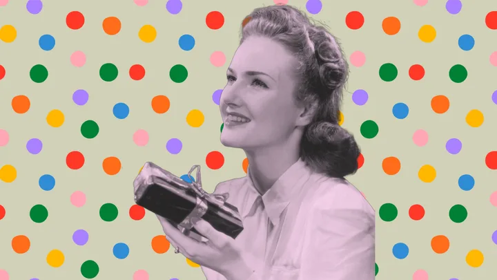 A retro-style woman smiling, holding a wrapped gift, against a colorful polka dot background.