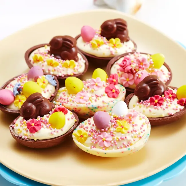 Chocolate egg halves with creamy filling, decorated with mini chocolate bunnies, candy flowers, and colorful sprinkles.
