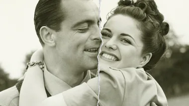 Black-and-white photo of a smiling couple with a tear through the middle, suggesting separation.