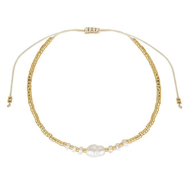 Gold beaded bracelet with white pearls and adjustable cord in a circle layout.