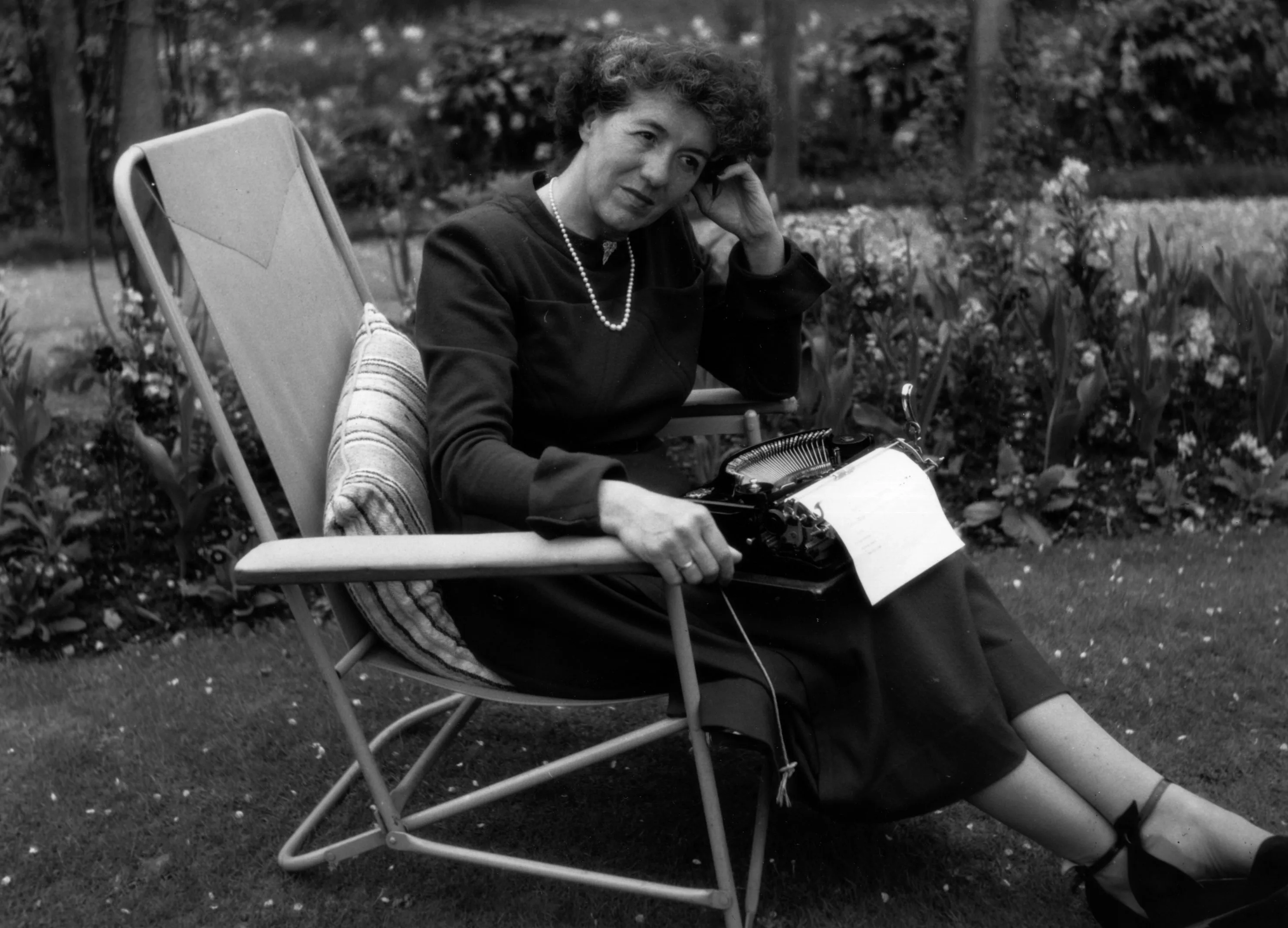 Enid Blyton sitting in her garden in Beaconsfield, Buckinghamshire. (Credit: Getty Images)