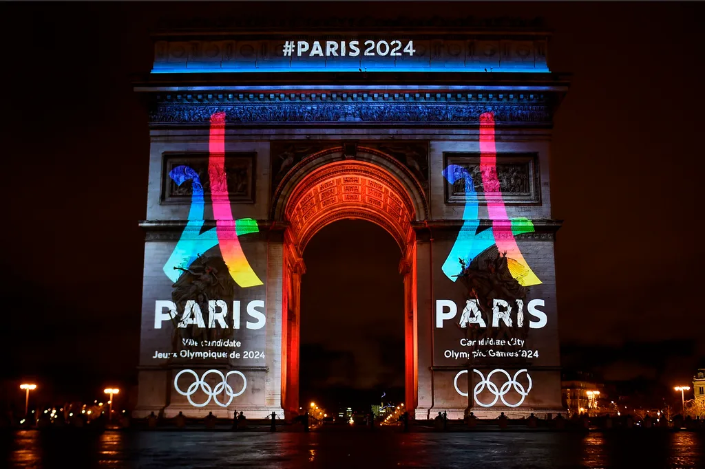 the arc de triomphe lit up in honour of the paris 2024 olympics