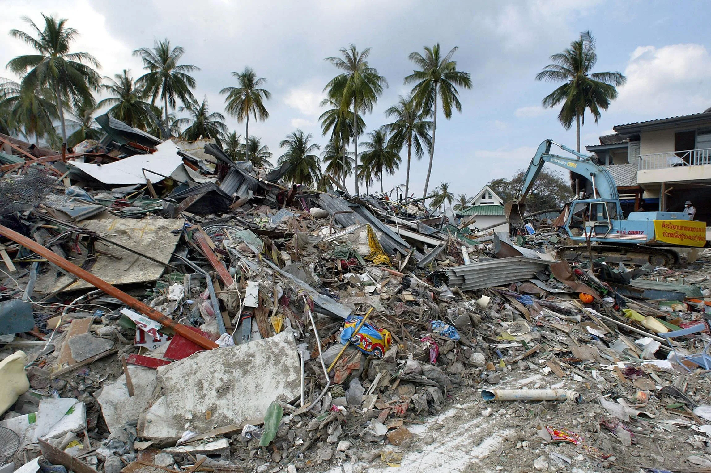 The job of cleaning up debris continues as a Thai rescue team works on the mess Phi Phi island, 31 December 2004. Photo by PORNCHAI KITTIWONGSAKUL/AFP via Getty Images.