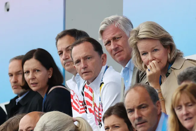 A group of people seated together at an event, some looking towards the camera with attentive expressions.