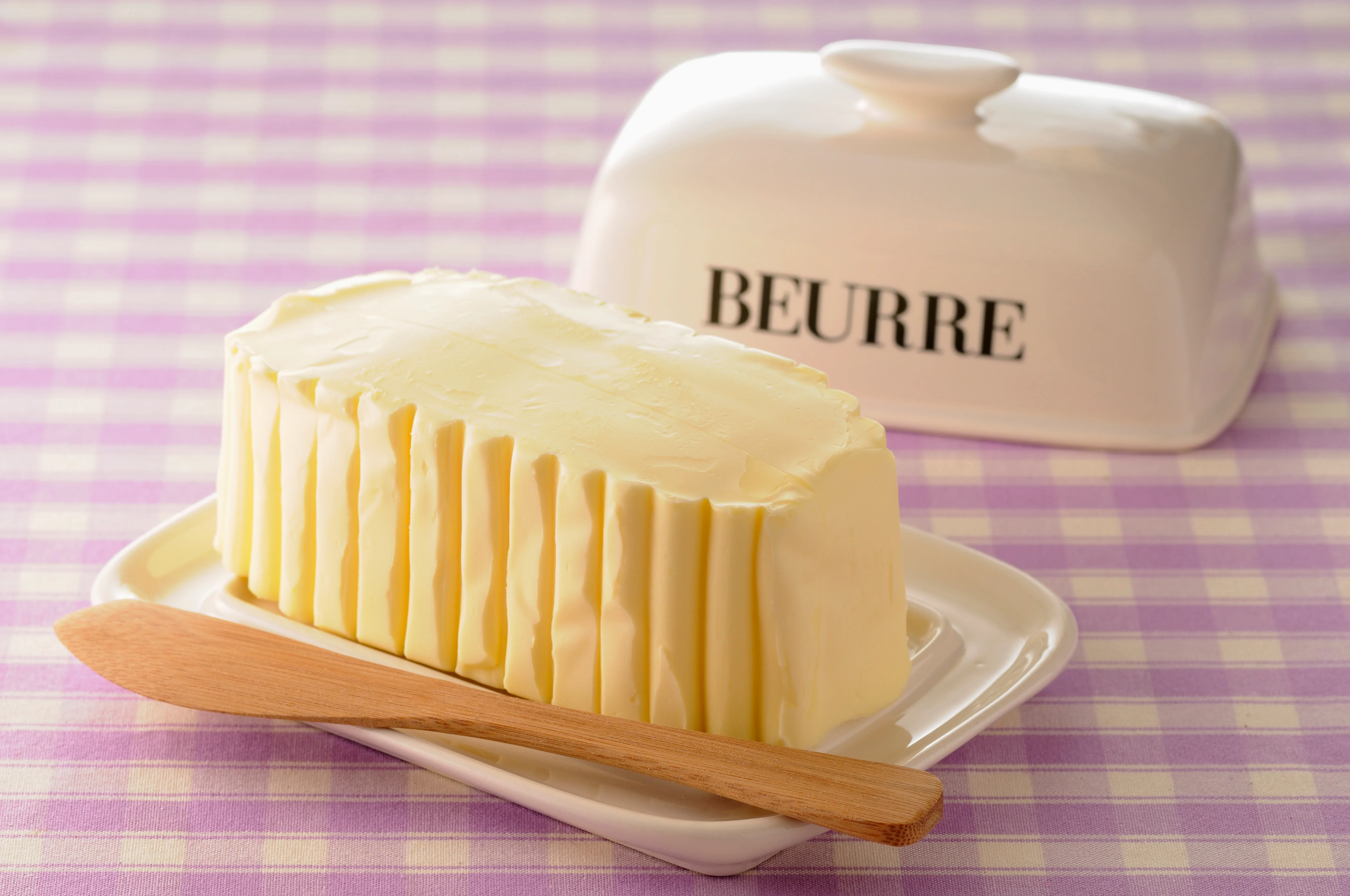 Butter in a butter dish on check tablecloth
