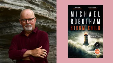 Author standing by rocks, next to cover of "Storm Child" by Michael Robotham. Lighthouse amidst stormy seas depicted.