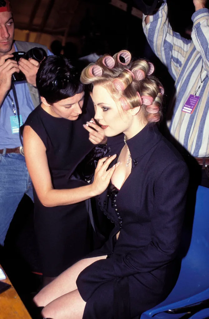 A blonde woman with rollers in her hair preparing for fashion week australia