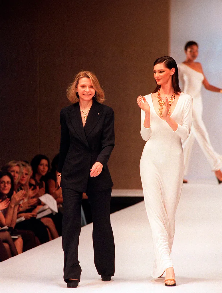Two women walk down a catwalk