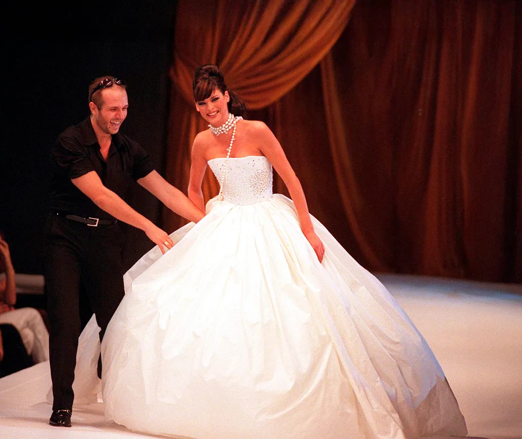 A woman in a wedding dress being helped my a man wearing black