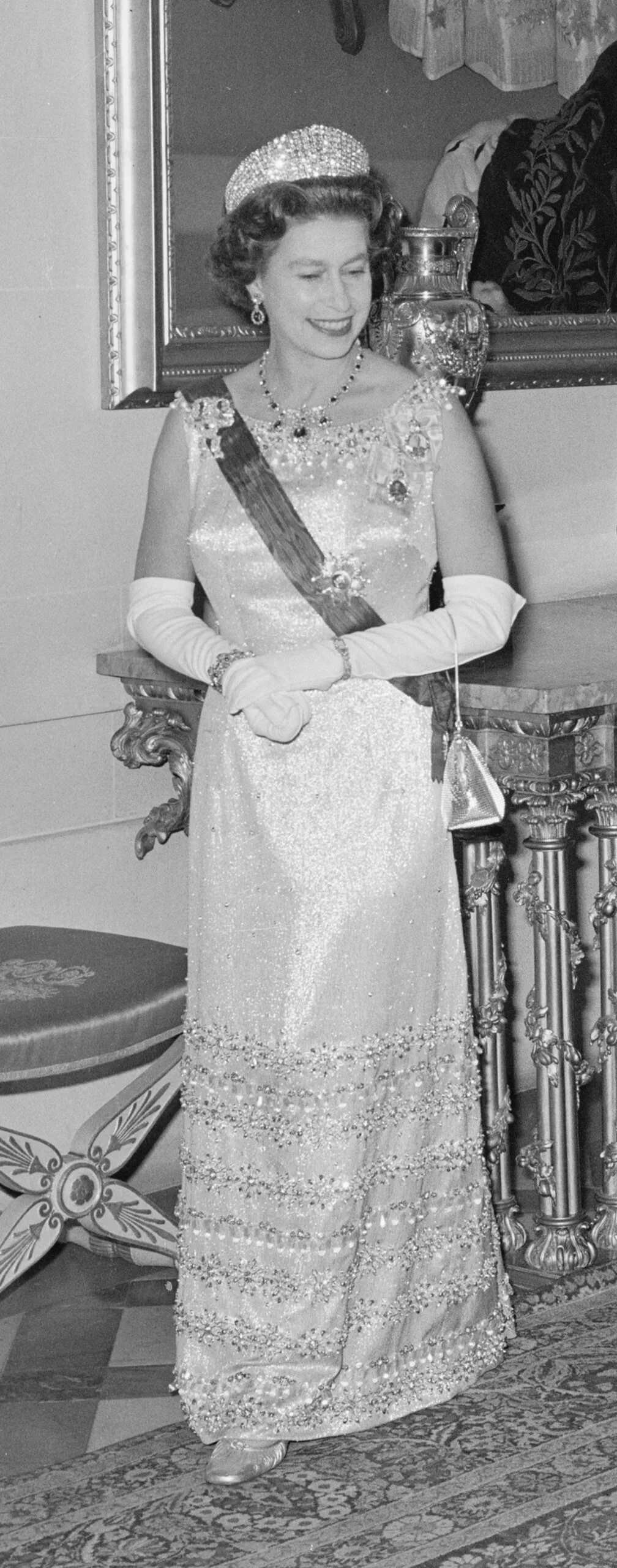 Queen Elizabeth II in a sparkling gown with long white gloves and a tiara