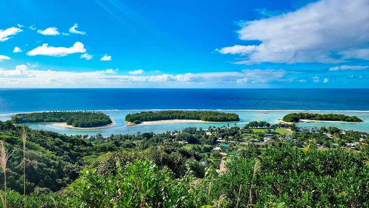 small islands in a lagoon and the ocean beneath a blue sky