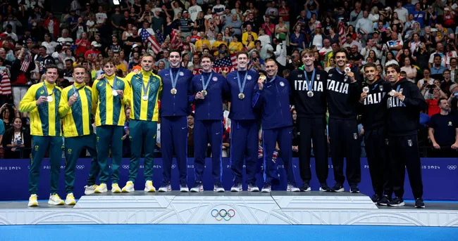 Australian, American, and Italian swim teams on podium with medals at the Paris 2024 Olympic Games.
