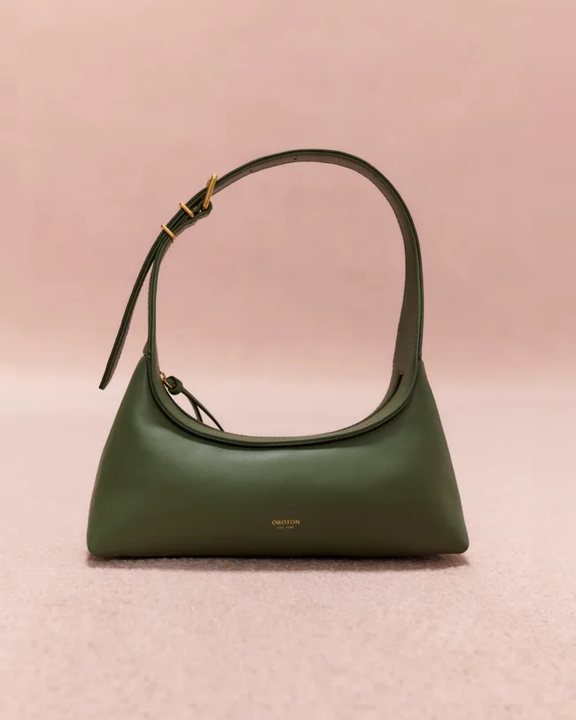 Green Oroton handbag with a curved silhouette and adjustable strap, set against a neutral background.