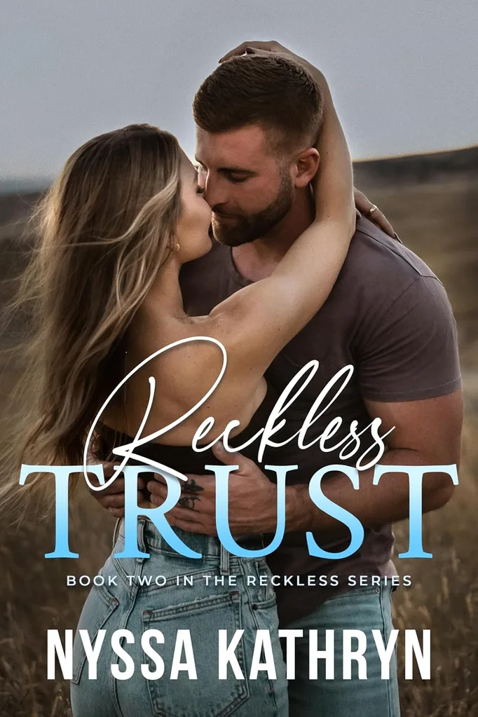 A couple embraces, about the kiss, on a hillside.