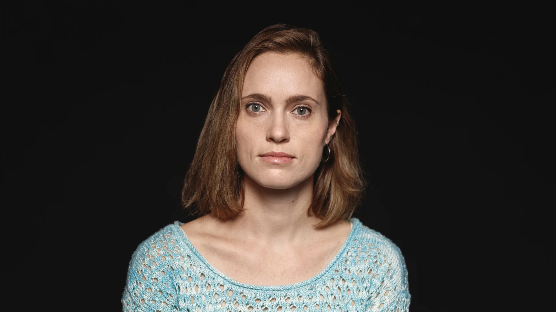 Woman against a blackdrop.