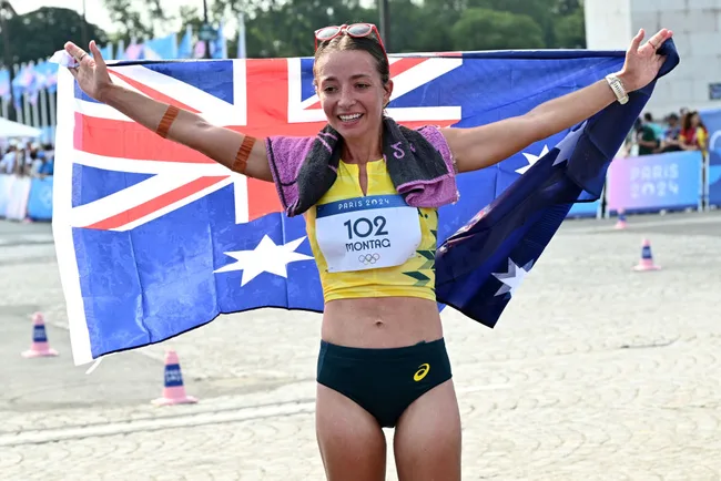 Athlete celebrating with Australian flag at Paris 2024 Olympics, wearing race number 102.