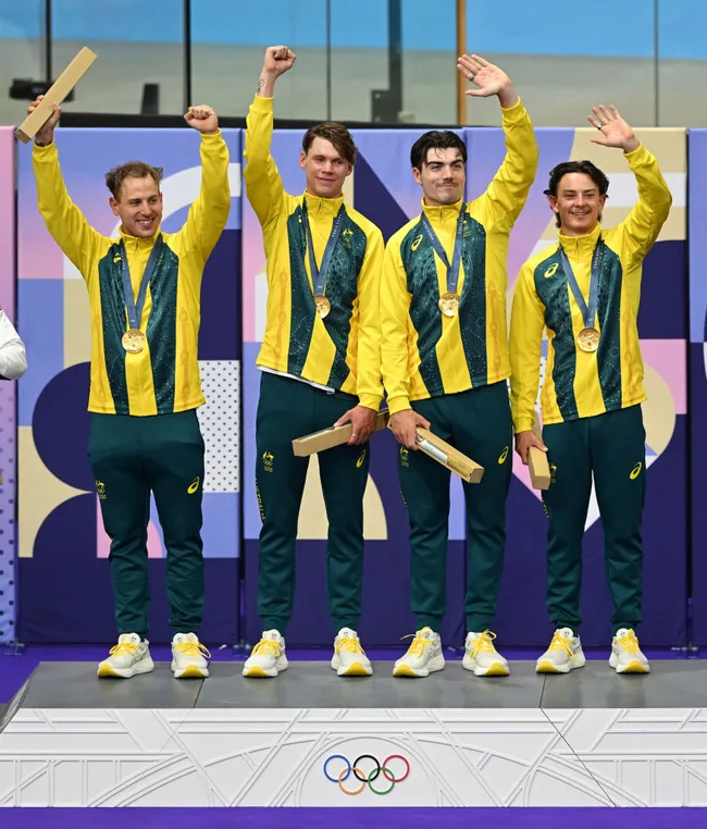 Australian men's relay team celebrating gold at the 2022 Commonwealth Games, wearing yellow and green tracksuits.