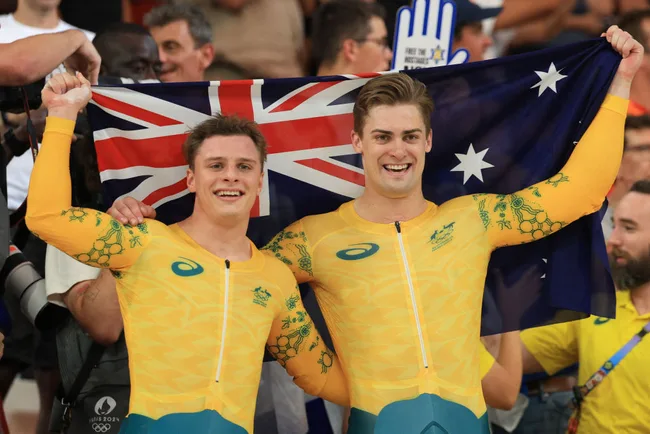 Australian cyclists celebrate with national flag after race.