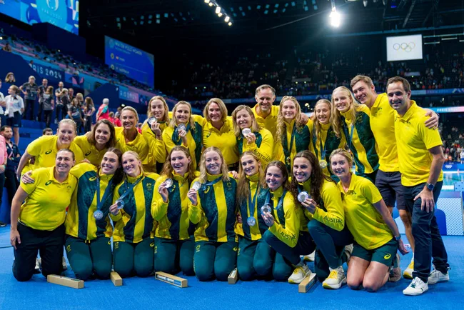 Australian women's volleyball team celebrating with their silver medals at the 2023 Paris Olympics indoor venue.