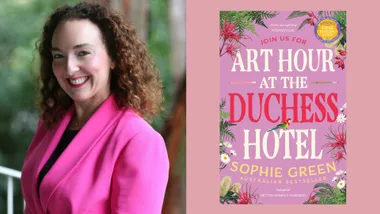 A woman in a pink blazer smiles beside the book cover of "Art Hour at the Duchess Hotel" by Sophie Green.