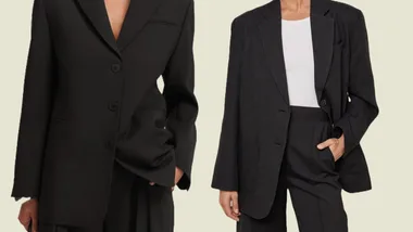 Two models wearing oversized black blazers with matching trousers on a light background.