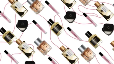 Various perfume bottles and vials with pink trails on a white background.