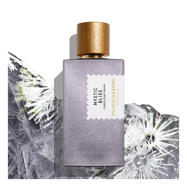 Perfume bottle of Mystic Bliss by Goldfield & Banks, with metallic cap and floral background.