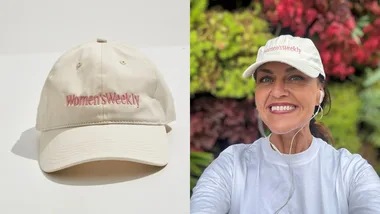 "Woman wearing a 'Women's Weekly' cap and headphones, smiling; cap alone on white background."