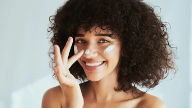 Headshot of woman with cream on her face