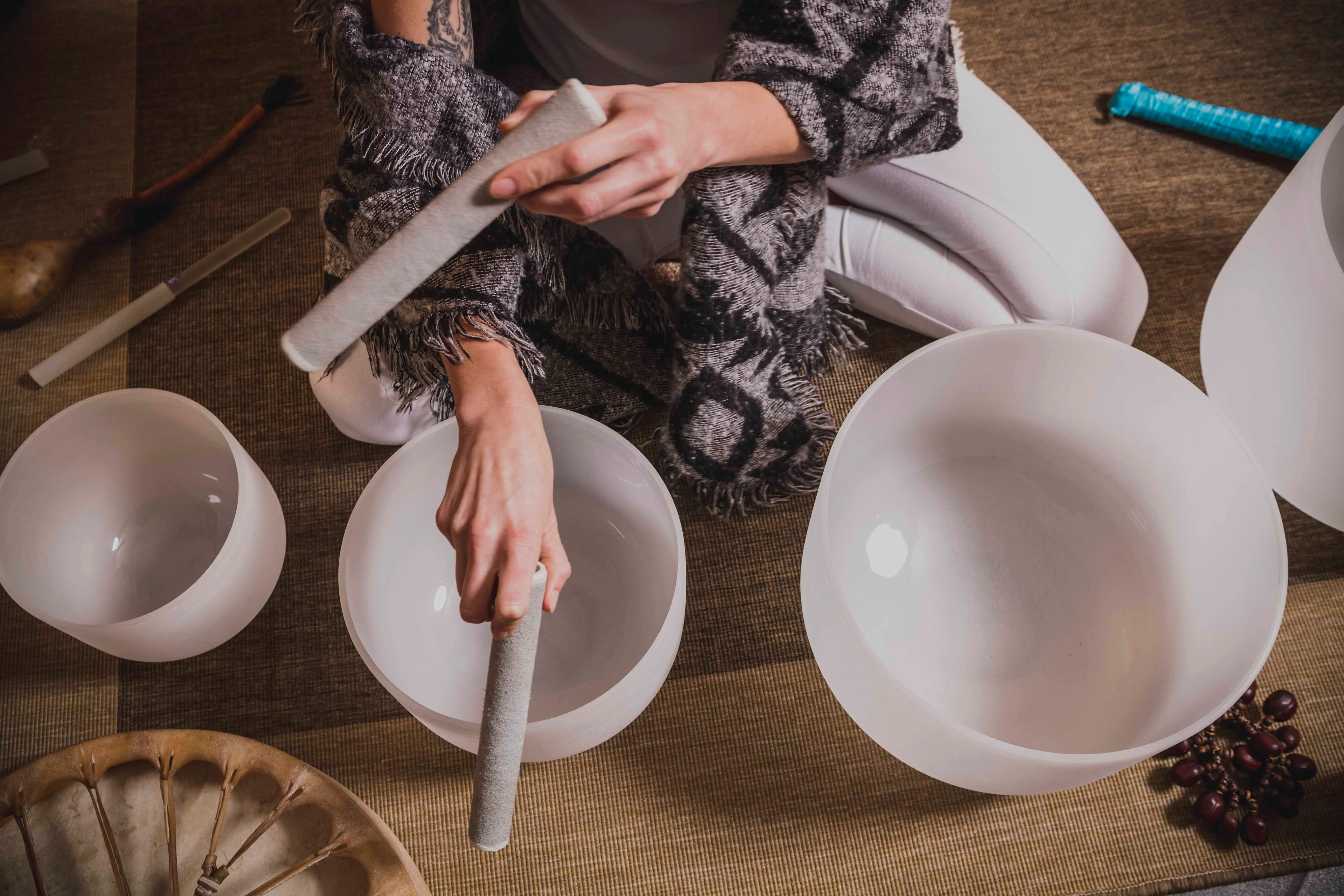 A woman using crystal bowls for sound healing. 