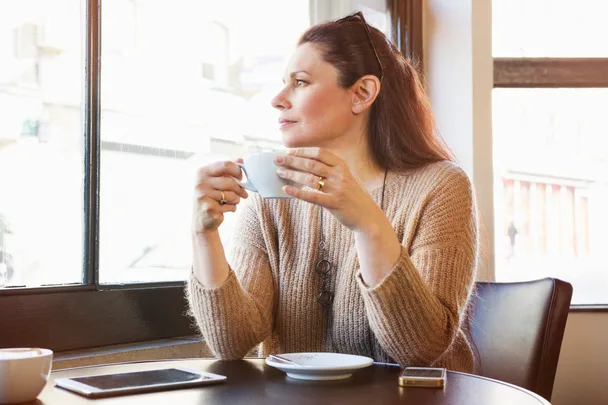 senior woman is drinking coffee in cafe