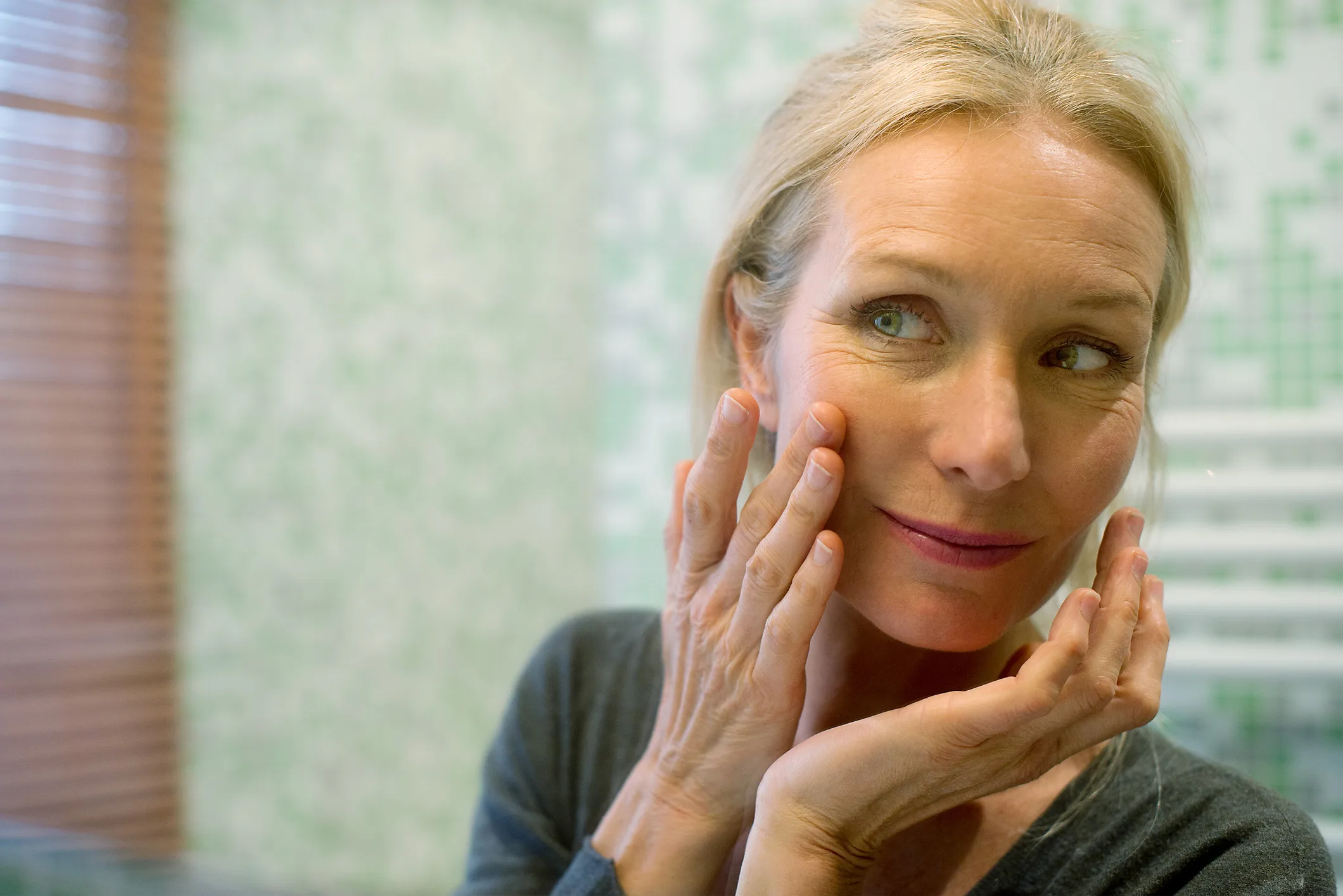 A woman applies skincare