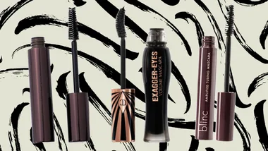 Four tubes of mascara with black and brown packaging against a black and white abstract background.