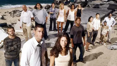 Group of people stand on a beach with airplane wreckage in the background, reminiscent of a survival scenario.