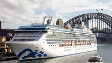 Cruise ship Coral Princess docked in Sydney with the Harbour Bridge in the background.